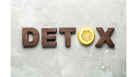 Detox spelled out with wooden letters and a lemon slice replacing the 'O'.