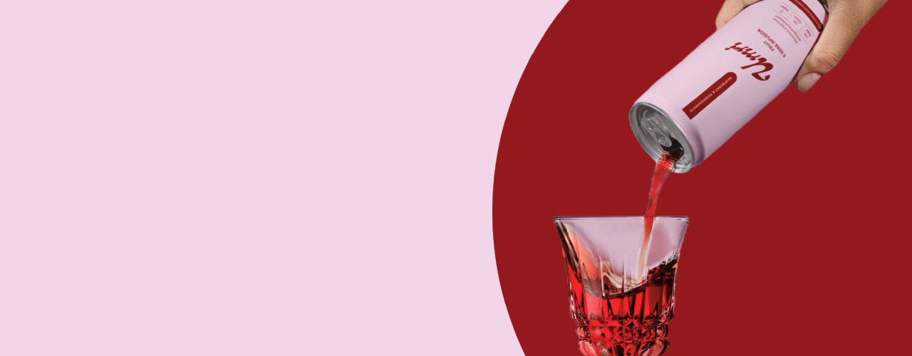 Canned drink being poured into a glass with a pink background